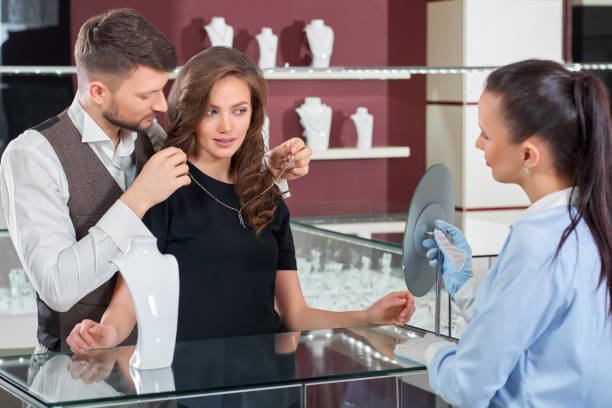 istock Young man helping his girlfriend with fitting necklace at the je 840902124