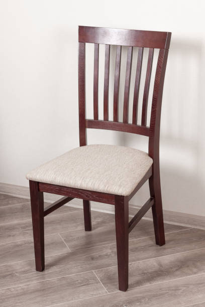 istock Wooden Chair with Cushion Against a White Wall 840906238