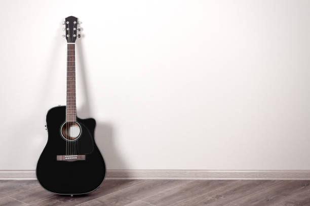 istock Black Classical Acoustic Guitar in an Empty Room with Copy Space 840908246