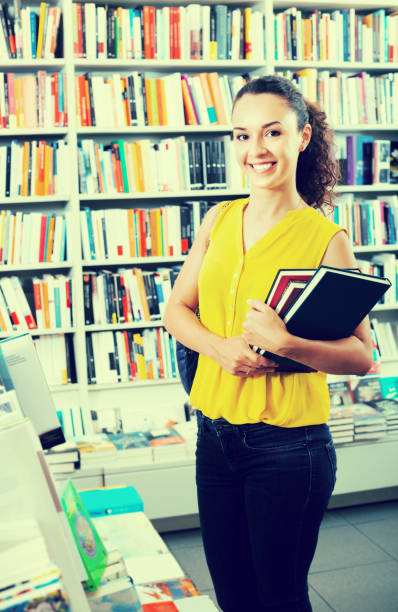 istock Happy woman reader holding books in bookstore 840915622