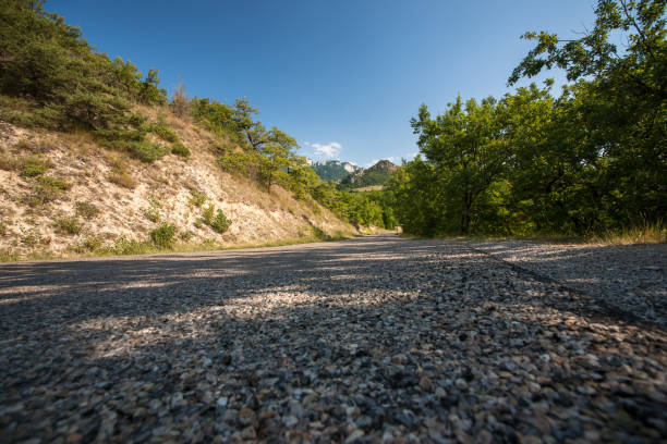 Mountain landscape with winding mountain road between the oak trees and the agricultural fields.