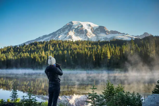 Photo of The Woman Photographer Taking Pictures of Mountain and Lake