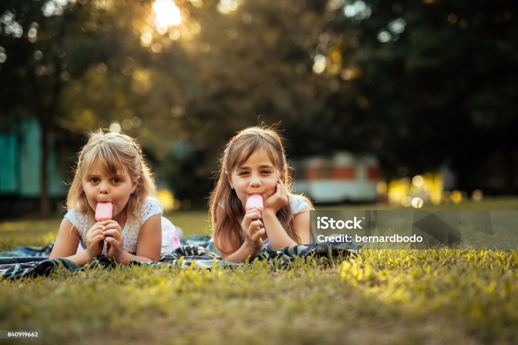 Enjoying ice cream Girls lying on a grass and eating ice cream. Ice Cream Stock Photo