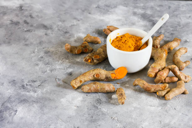 istock Turmeric root and ground turmeric. White bowl, gray background. 840920482