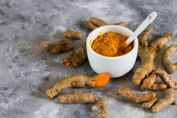 istock Turmeric root and ground turmeric. White bowl, gray background. 840920754
