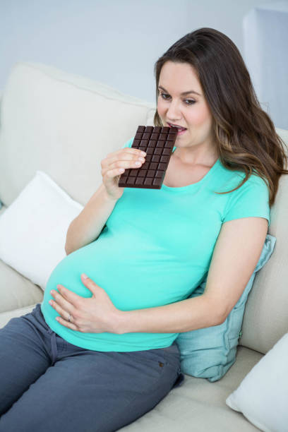 istock Smiling pregnant woman eating chocolate 840927930