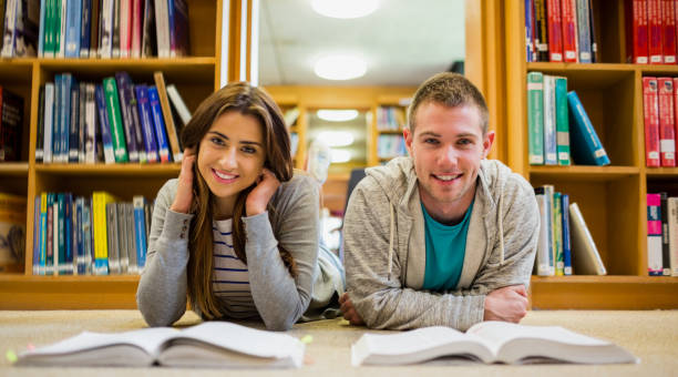 istock Students with books lying on the library floor 840930402