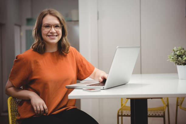 istock Portrait of smiling female executive using laptop 840930420