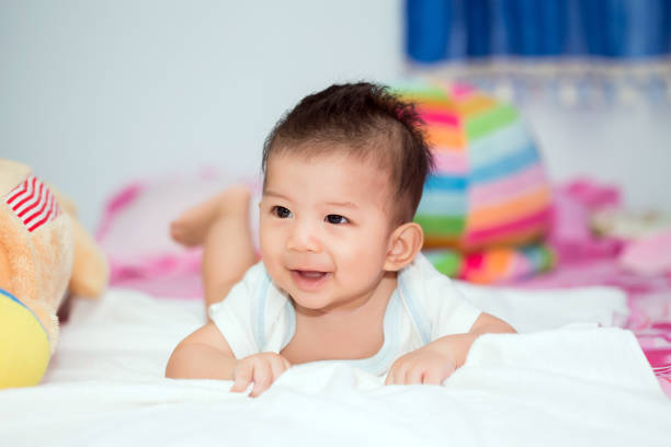 istock Cute baby in bed smiling and looking at camera. 840930824