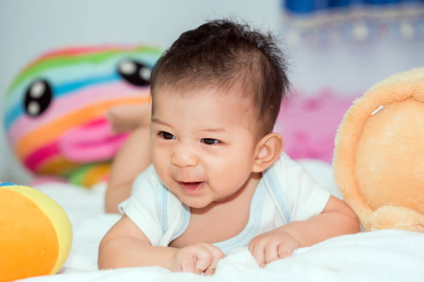 istock Cute baby in bed smiling and looking at camera. 840930944