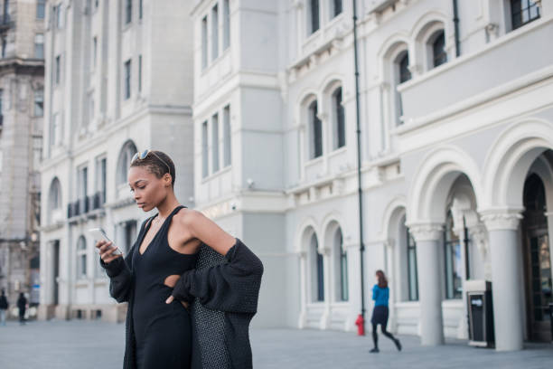 Young woman standing on the street and using phone