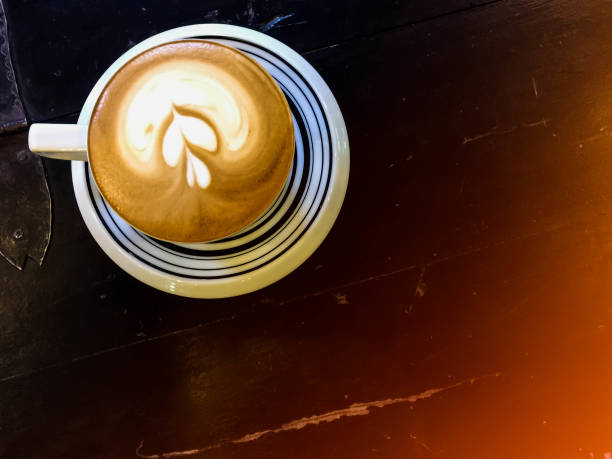 istock Cappuccino and water on the table with sun light 840935632