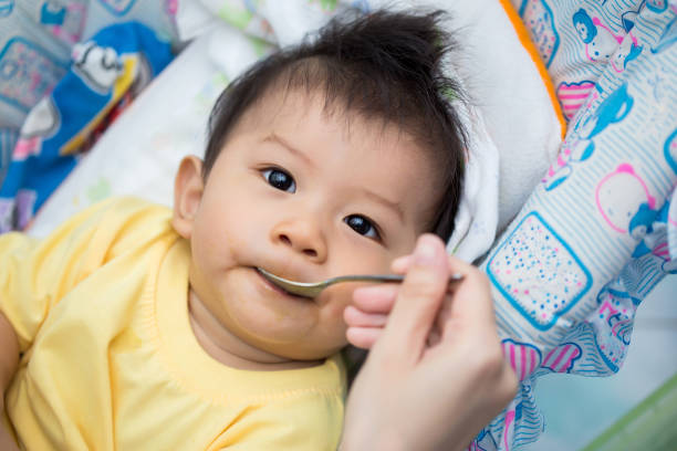 istock Mom feeds baby with spoon 840936252