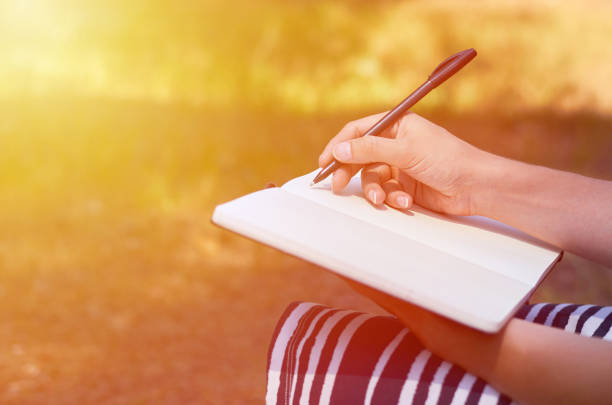 istock A girl writes her hand in a notebook. Study and work in the park 840939620