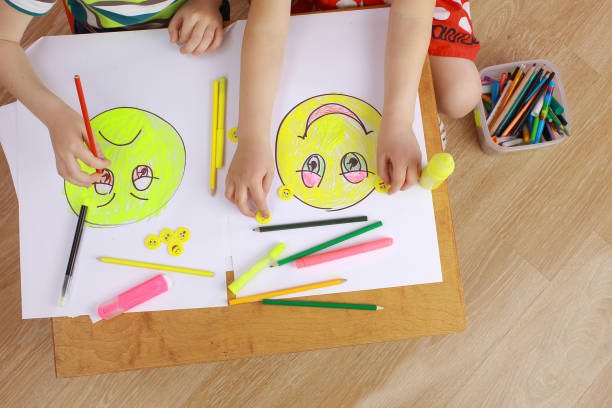 the development of emotional intelligence. child psychology. girl and boy depict different emotions. the girl and the boy draw happy and sad emoticons psyche photography stock pictures, royalty-free photos & images