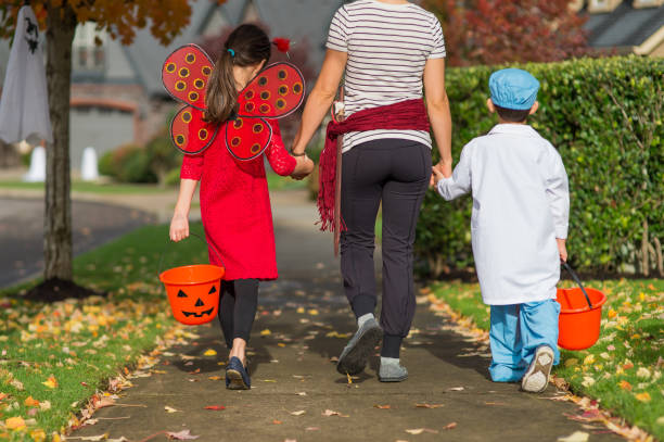 двое детей в хэллоуин костюмы трюк или лечения - mobilestock outdoors horizontal rear view стоковые фото и изображения