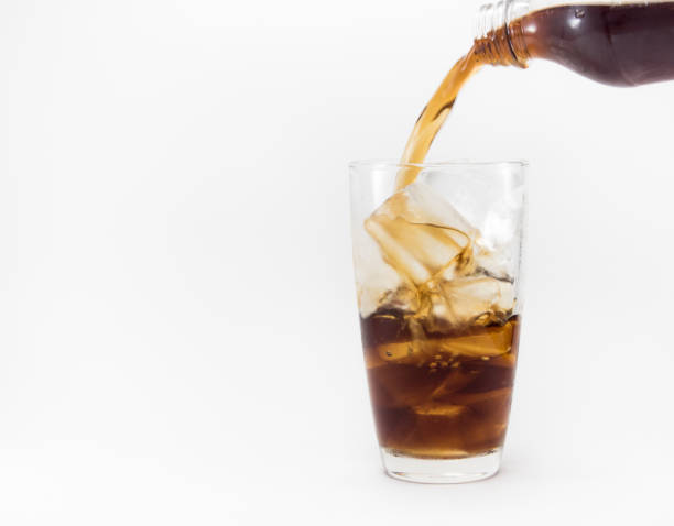 istock cola pouring from a plastic bottle into a glass filled with ice cubes 840943952