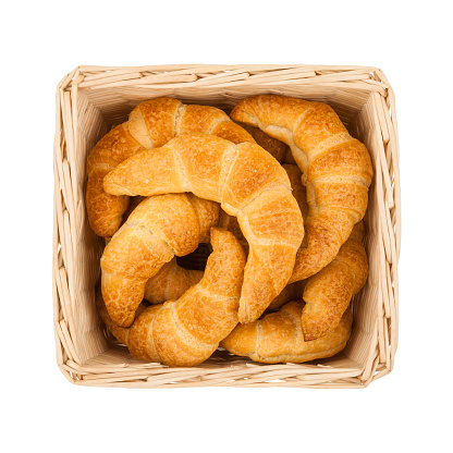 Basket with freshly baked homemade croissants isolated on white background, top view