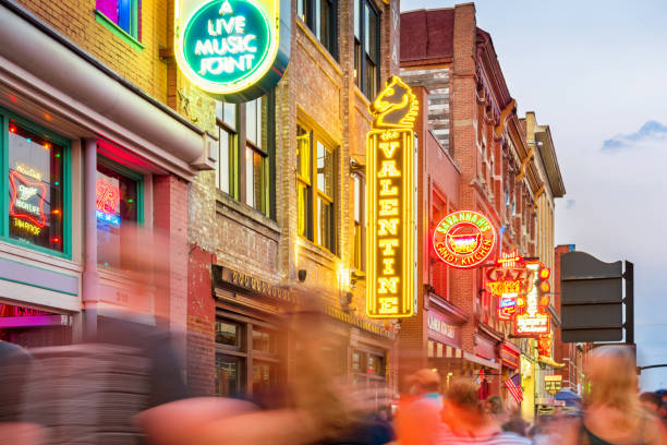 Broadway pub district in downtown Nashville Tennessee USA Stock photograph of people and colorful neon signs in a row at the landmark Broadway pub district in downtown Nashville, Tennessee, USA, illuminated at twilight blue hour blue hour twilight photos stock pictures, royalty-free photos & images