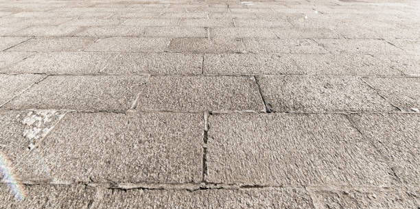 vista en perspectiva de piedra ladrillo gris monótono sobre el terreno para el camino de la calle. acera, calzada, adoquines, pavimento en vintage diseño pisos plaza patrón textura de fondo - paving stone avenue stone curve fotografías e imágenes de stock