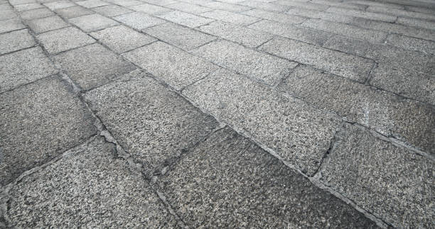 vista en perspectiva de piedra ladrillo gris monótono sobre el terreno para el camino de la calle. acera, calzada, adoquines, pavimento en vintage diseño pisos plaza patrón textura de fondo - paving stone avenue stone curve fotografías e imágenes de stock