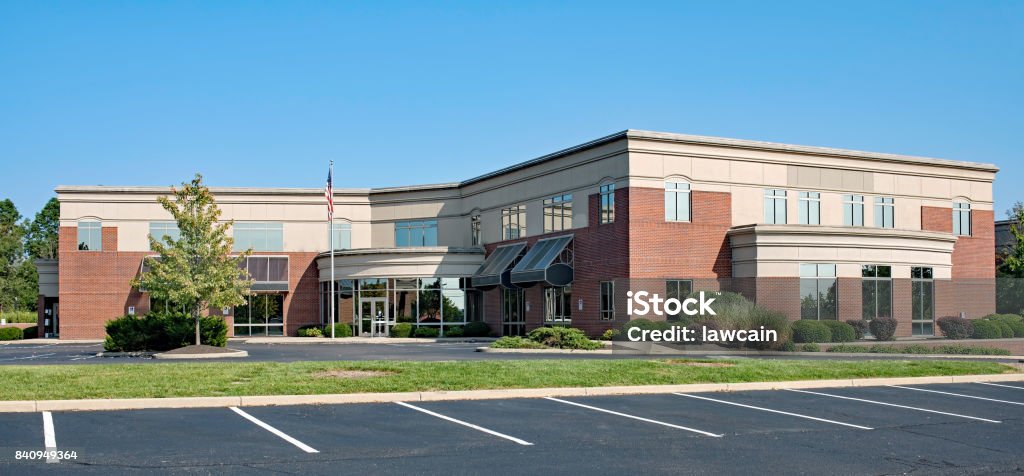 Red Brick Building with Concave Entrance Modern, two story, red brick building with curved, concave entrance. Office Building Exterior Stock Photo