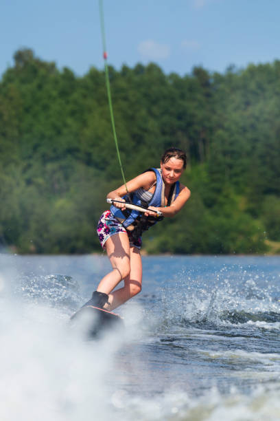 istock slim brunette woman riding wakeboard on lake 840961518