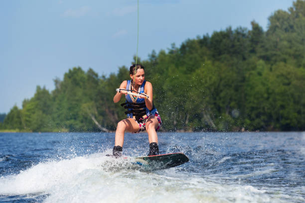 istock slim brunette woman riding wakeboard on lake 840968198