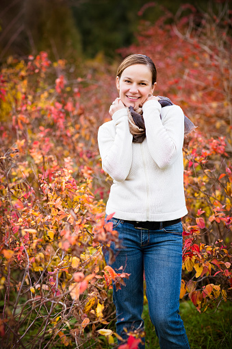 Young pretty smiling woman in autumn forest