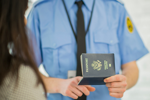 A woman shows a passport, female hands, close-up, background blur.