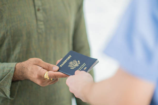 überprüfung des pass - customs official examining emigration and immigration document stock-fotos und bilder