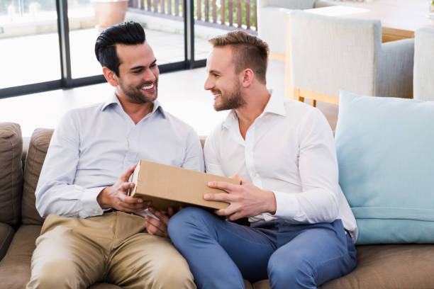 istock Smiling man offering gift to his boyfriend 840990100