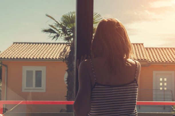 istock Lonesome girl watching through the room window. 840991162