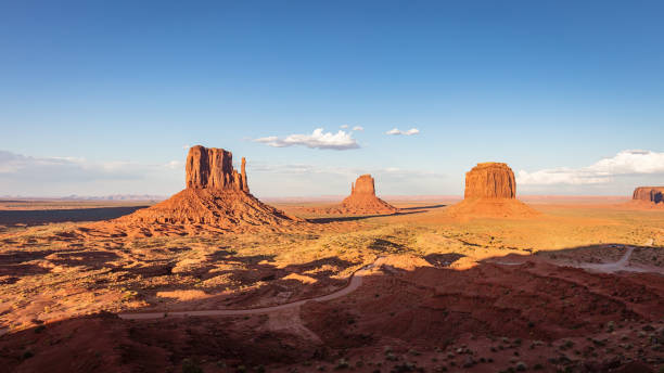 Monument Valley Panorama Arizona USA Panorama of the scenic view in late afternoon light close to dusk towards the famous West Mitten Butte and Merrick Butte under beautiful summer sky. Monument Valley, Arizona, USA. merrick butte stock pictures, royalty-free photos & images