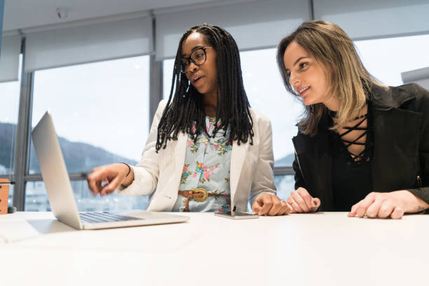 istock Young businesswomen using laptop in creative office 840993842