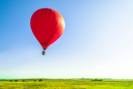 Cappadocia, Turkey- May 29, 2022: A hot air balloon lands on a road where cars are driving