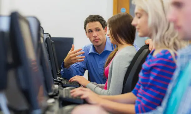 Photo of Teacher explaining to students in the computer room