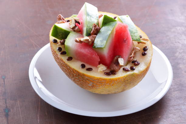 istock Melon stuffed with watermelon, sprinkled with walnut on a white plate 841001636