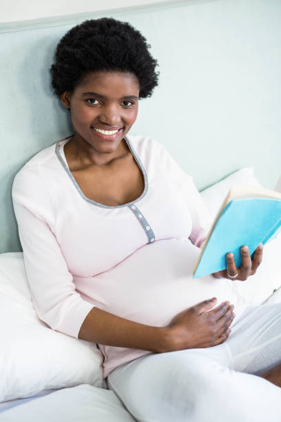 istock Pregnant woman reading a book 841002028
