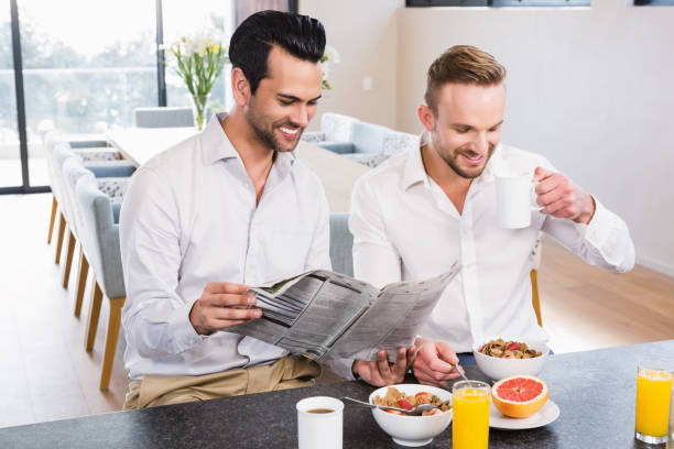 istock Smiling gay couple reading newspaper 841016084