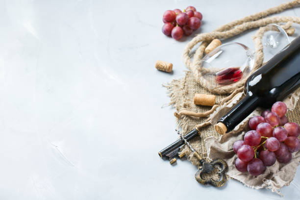 istock Bottle, corkscrew, glass of red wine, grapes on a table 841023422