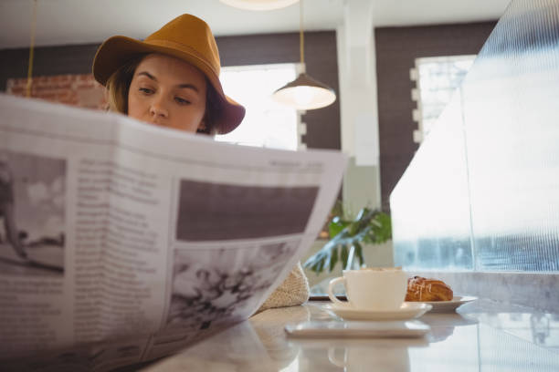 istock Woman reading newspaper in cafe 841023694