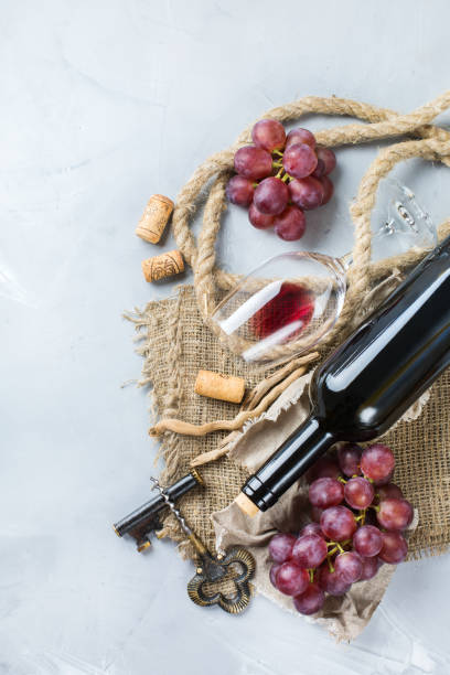 istock Bottle, corkscrew, glass of red wine, grapes on a table 841025922