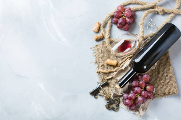 istock Bottle, corkscrew, glass of red wine, grapes on a table 841026258