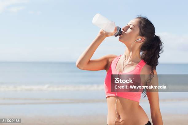 Photo libre de droit de Eau Potable Saine De Belle Femme Sur La Plage banque d'images et plus d'images libres de droit de Brassière de sport - Brassière de sport, 18-19 ans, Activité physique