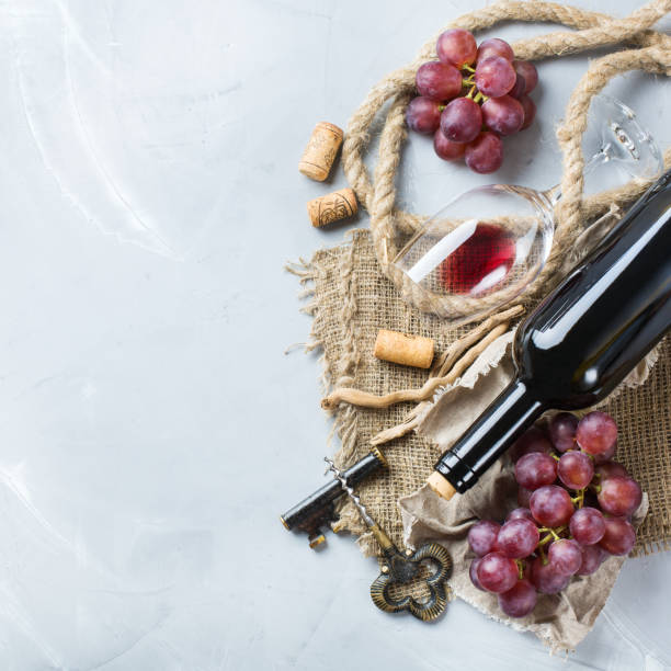 istock Bottle, corkscrew, glass of red wine, grapes on a table 841029664
