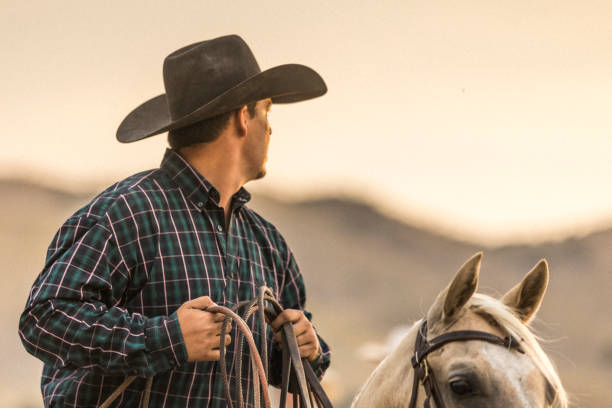 istock At sunset, a cowboy horseback riding on a ranch. 841033126