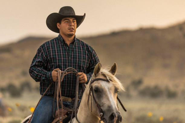 istock At sunset, a cowboy horseback riding on a ranch. 841033128