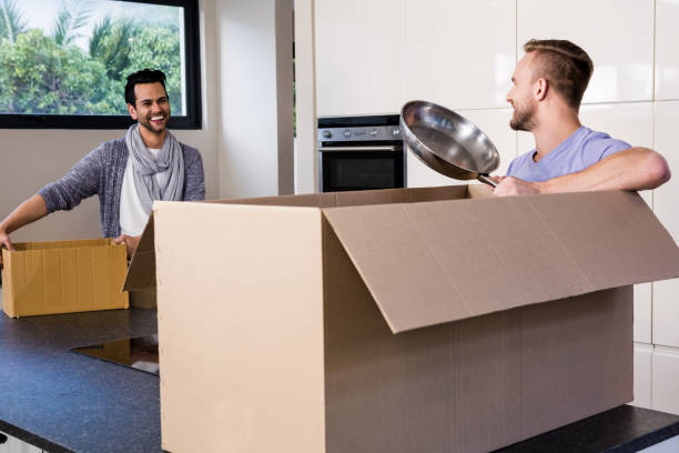 istock Smiling gay couple unpacking cardboard 841037138