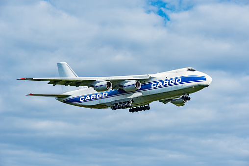 Flight of the big cargo airliner at sunny day time.